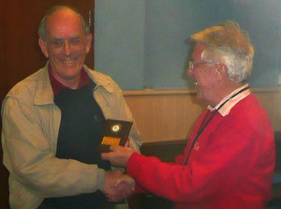 Brian receiving the mini shield from Laurie