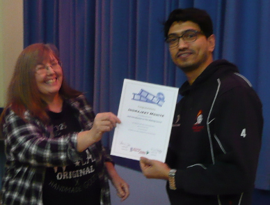 Karen presents Indrajeet with his belated course certificate