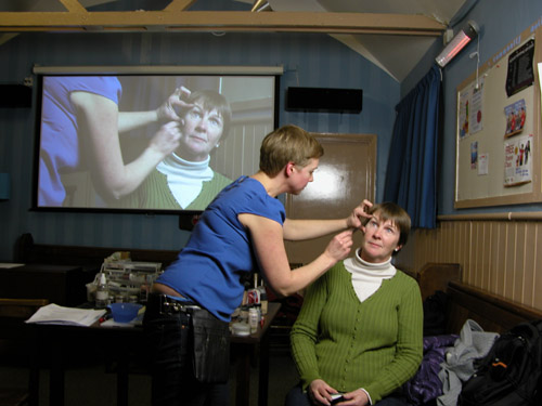 Vikki applying make-up to Anne with the camera image projected onto the screen